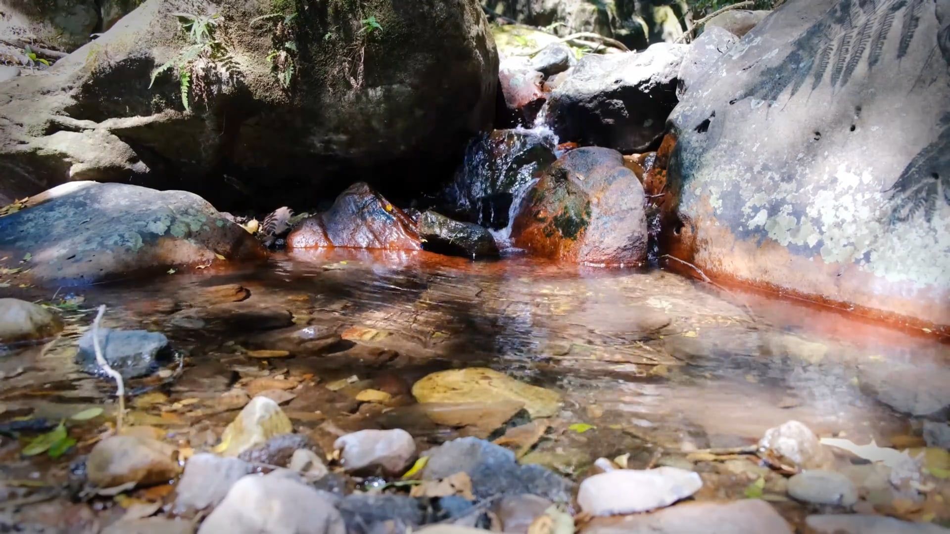 Low Angle Footage Of Clear Water Flowing Down From The Rocks To A ...