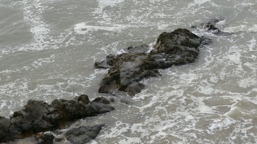 海岸の岩層に衝突する海の波