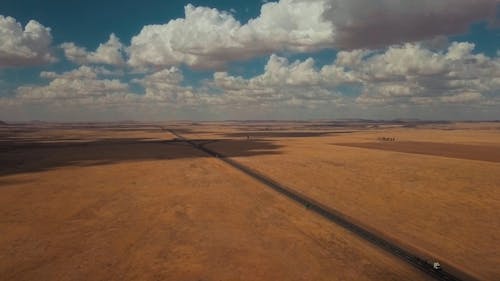 An Asphalted Concrete Road In The Middle Of An Open Field