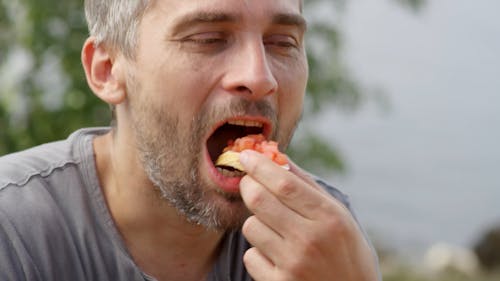 Um Homem Provando Um Pão Com Recheio