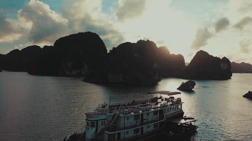 A Boat Anchored At Sea Besides The Rocky Hills Islands 