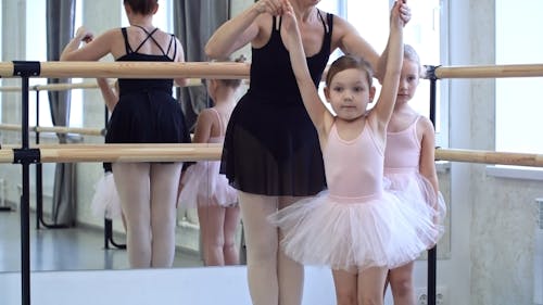 A Ballet Teacher Teaching Young Students Ballet Moves And Forms