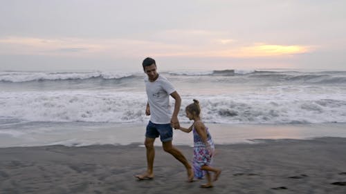 Ojciec Biegnie Z Córką Na Piasku Na Plaży