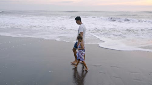 父親和女兒沿著海岸散步