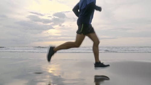 A Man Running On The Beach Shore