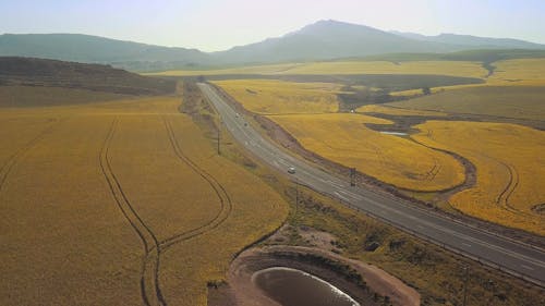 Drone Footage Of A Road Built Crossing A Large Area Of Farm Lands