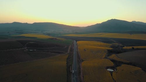 Aerial Footage Of A Road Cutting Through Agricultural Lands