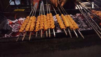 a person grilling meat in the street