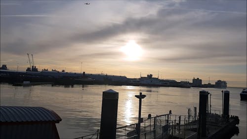 A Yacht Docking On A Sea Harbor At Sunset