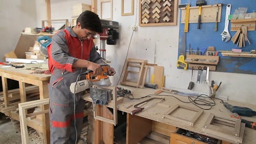 Un Uomo Che Lavora In Un Laboratorio Di Legno Che Realizza Cornici