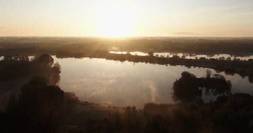 Blendung Der Aufgehenden Sonne, Die Von Einer Seeoberfläche Reflektiert