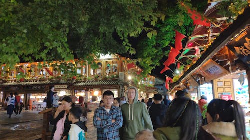 A Crowd Of People Visiting A Street Full Of Food Stores And Shops