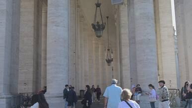visitors entering vatican city archway