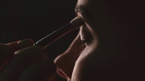 A Woman Applying An Eye Shadow Makeup On Her Eyelid