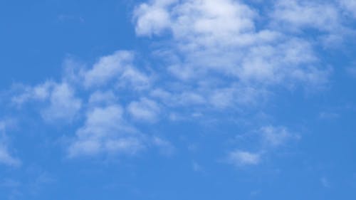 Een Vliegtuig Vliegen Door De Wolken Onder Een Blauwe Lucht