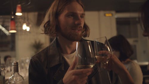 A Man Tossing Glasses With A Woman In A Bar