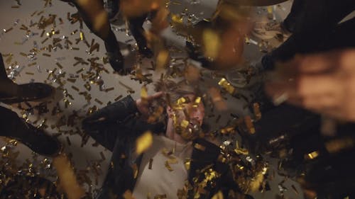 Dropping Confetti On A Man Lying Down On The Floor