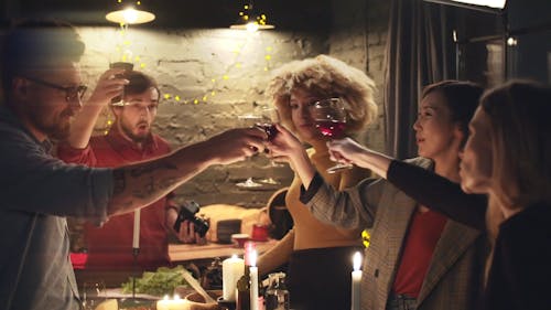 A Group Of People Tosses Their Glasses Of Wine In Unison