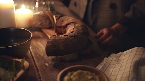 A Crescent Shape Loaf Of Bread On A Chopping Board Over A Table