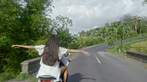 A Couple Riding A Motorcycle In A Road Trip To The Countryside