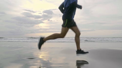 一個男人在海灘海岸線上奔跑