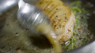 person frying a chicken fillet