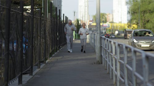 Ein älteres Paar, Das Auf Dem Bürgersteig Joggt