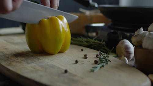 Человек, нарезавший желтый сладкий перец