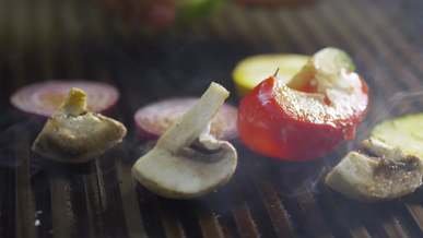 a variety of sliced vegetables being grilled