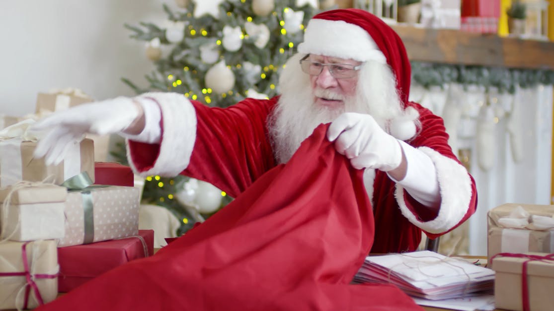 Santa Claus Putting Boxes Of Gifts In A Sack Free Stock Video