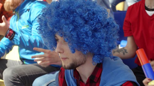 A Male Sport Fan Wearing A Colorful Wig To Show Support For His Team