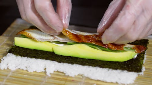 Making Sushi Roll Of Grilled Eel And Avocado