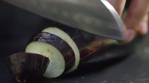 Cutting An Eggplant Into Slices Using A Knife
