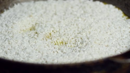 Placing A Clove Of Garlic On A Cooking Rice