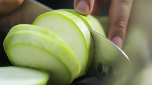 Slicing Bottle Gourd Vegetable Into Pieces Using A Knife