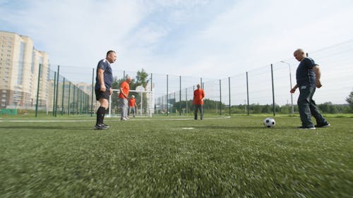 サッカーの試合をしている年配の男性のグループ