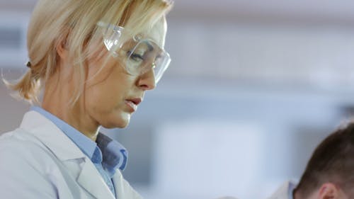 Scientist Working And Looking Through A Microscope