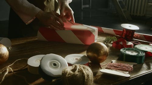 A Person Gift Wrapping A Box