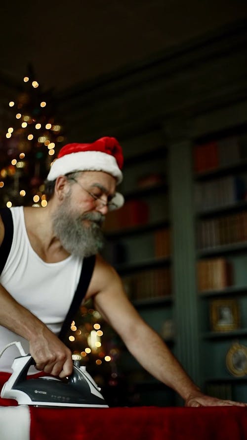 Hombre En Un Traje De Santa Claus Preguntando Mientras Plancha