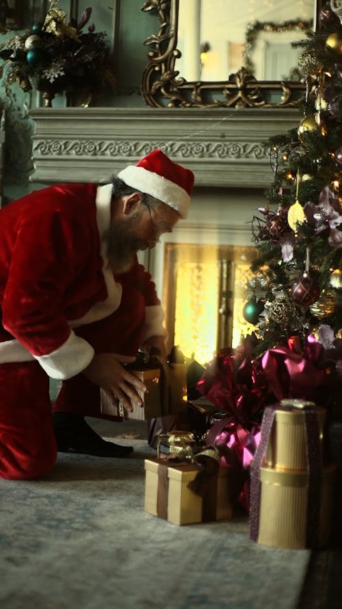Santa Claus Putting A Box Of Gift Under A Christmas Tree