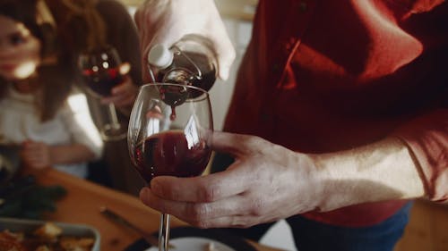 Eine Person, Die Rotwein Auf Einem Weinglas Poring