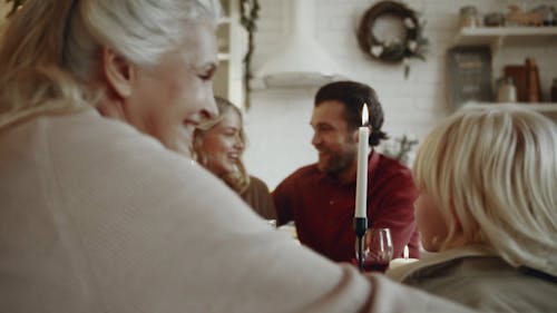 Uma Família Reunida Em Uma Mesa De Jantar, Mostrando Amor E Carinho Uns Pelos Outros