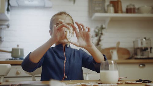 A Girl Putting A String On A Cookie To Hang