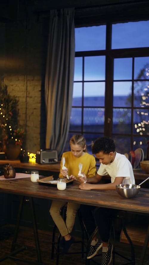 Two Kids Decorating Gingerbread Cookies