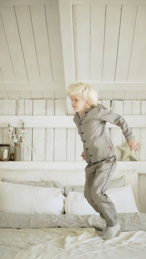 A Boy Jumping Up And Down In A Bed