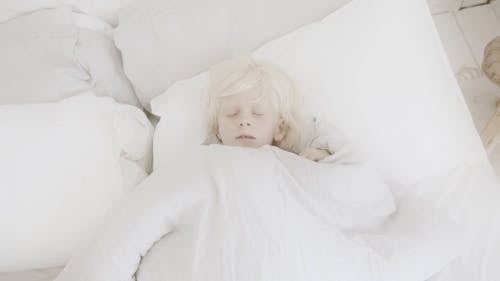 A Boy Lying In Bed To Sleep With A Teddy Bear Stuffed Toy