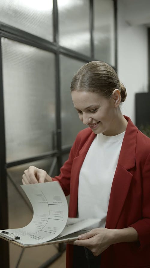 Woman With A Smiling Face While Looking Through Some Paperworks