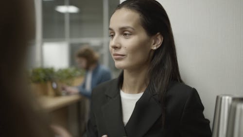 Woman Smiling While Listening To Her Colleague