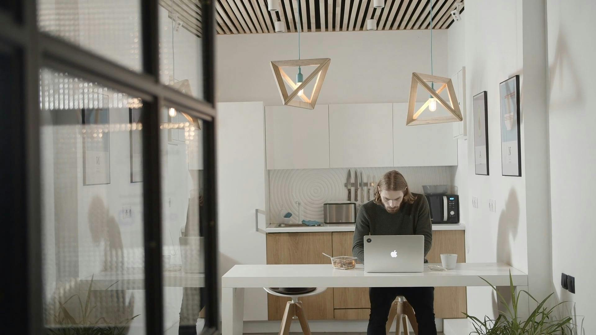 A Man In An Office Pantry Eating Breakfast While Working On A