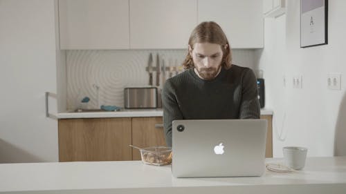 A Man Having His Meal While Working On A Laptop